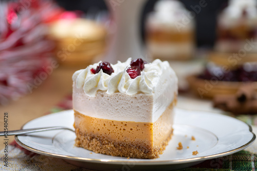 Christmas pumpkin and cranberry mousse on cake stand  on a festive table