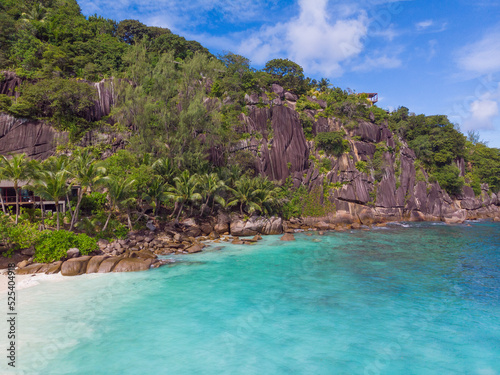 Amazing view of coastline surrounded by cliffs, sand, rocks and palm trees from Petite Anse at Mahé - Seychelles