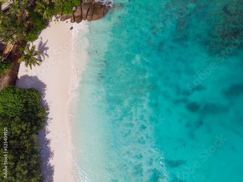 Aerial view from drone of Petise Anse beach at Mahé Island taken in the afternoon light