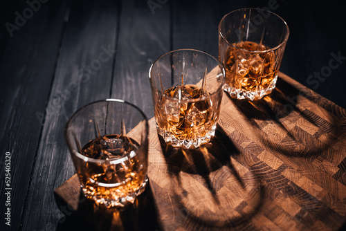 three glasses whiskey on wood table