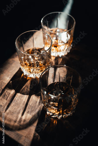 three glasses whiskey on wood table