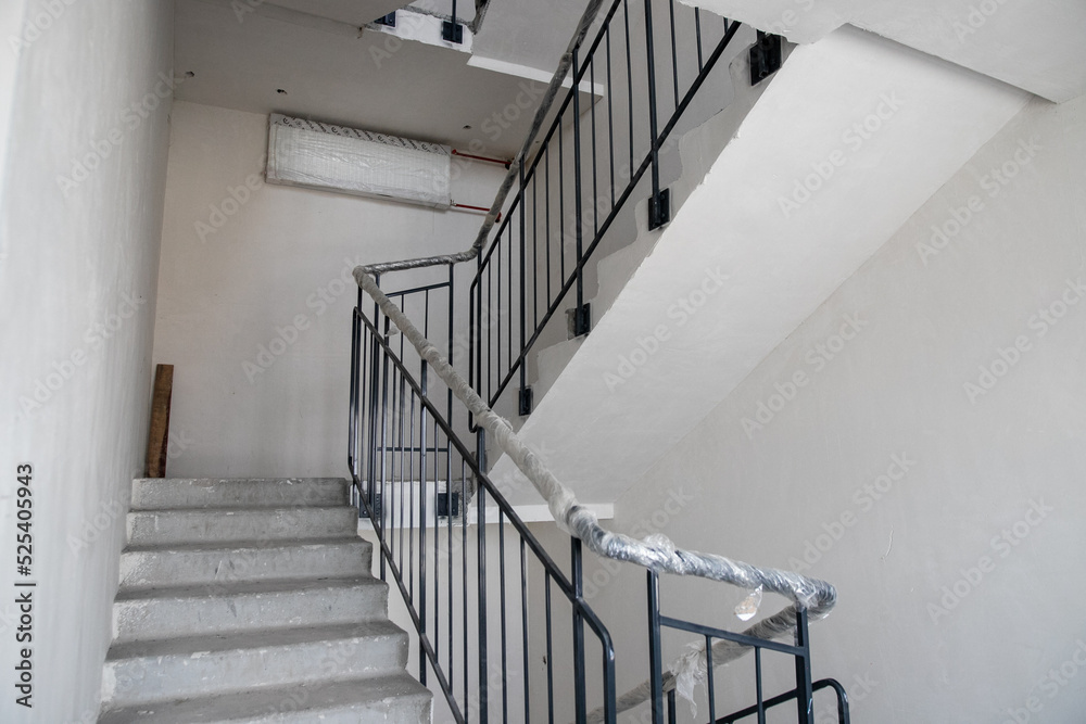 Fototapeta premium Repairs in the building. Building with a metal staircase at the time of renovation. Construction site in the house without people. Construction of a new house. Construction and architecture.