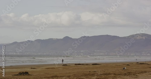 Person walking along beach at Oceano Dunes SVRA at Pismo Beach, California photo