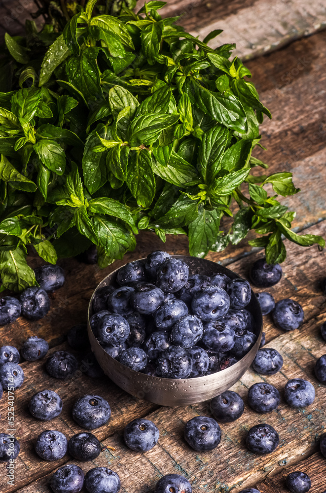 Bowl of blueberries and mint on a wooden table