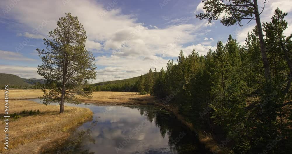 A large river in between grass plains in Yellowstone National Park A large river in between grass plains in Yellowstone National Park