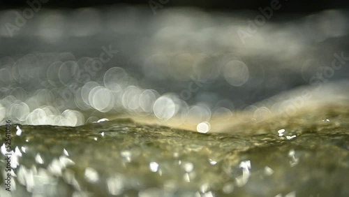 Water of a mountain river with rocks (bokeh, slow motion, close up)
