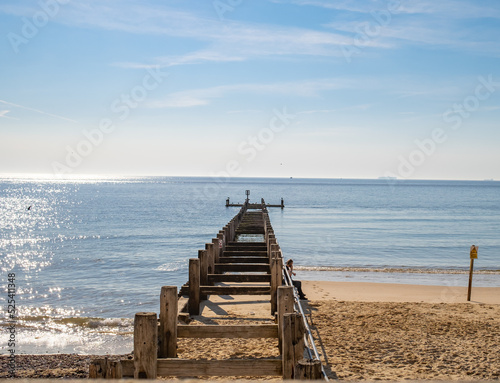 11..Lowestoft, Suffolk, UK – August 14 2022. Wooden groynes and breakers on the sandy beach in the seaside town of Lowestoft on the Suffolk Coast