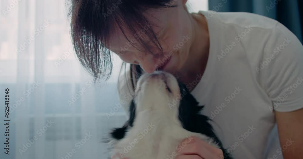 Woman kiss cute puppy while relaxing at home. Pets love Woman kiss cute puppy while relaxing at home. Pets love