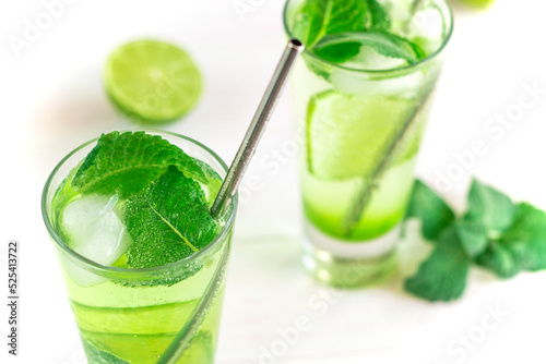 Glass of iced lemonade soda, cold drink in summer. Summer cold detox, healthy drink with mint, lime and ice. Green mojito cocktail. Classic recipe