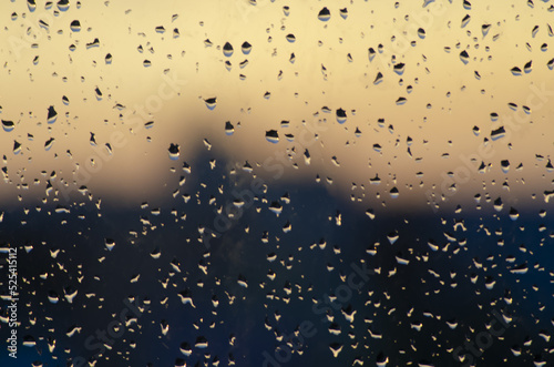 water drops on the window on sunset orange and black background
