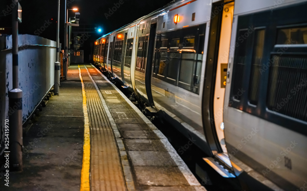 London, United Kingdom - February 02, 2019: Public transport train waiting at the empty platform in night, illuminated doors opened London, United Kingdom - February 02, 2019: Public transport train waiting at the empty platform in night, illuminated doors opened