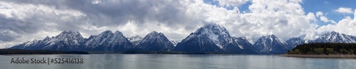Rocky Beach by the Lake with Mountains in Background. Spring Season. Grand Teton National Park. Wyoming, United States. Nature Landscape Panorama
