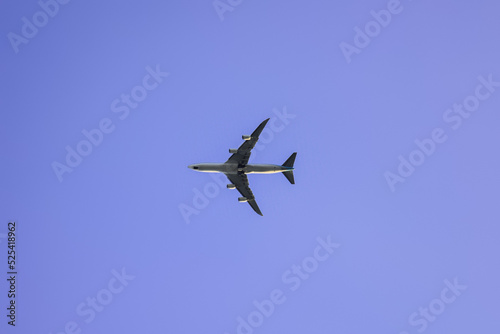 The plane flies against the blue sky. Travels.