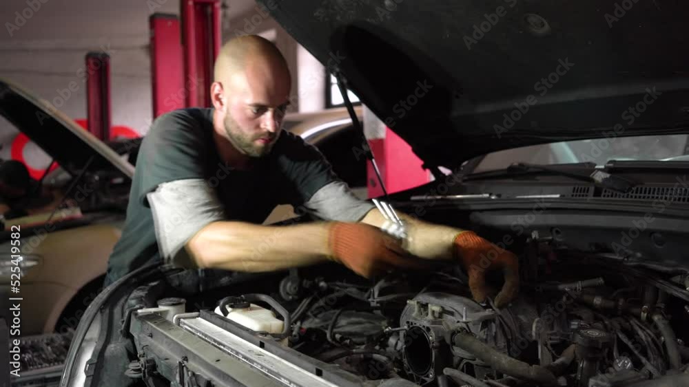 Auto mechanic repairs SUV engine. auto repair station. Auto mechanic repairs SUV engine. auto repair station.