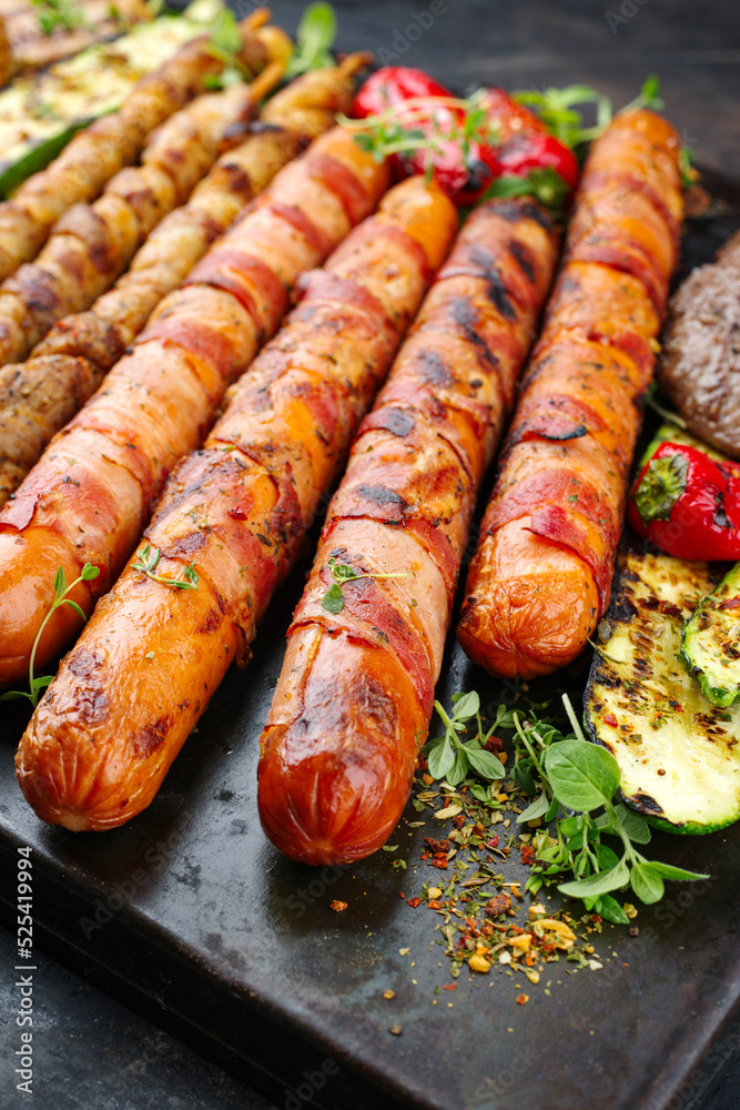 Foto de Traditional Grillplatte mit Bratwurst, Hamburger und Speck ...