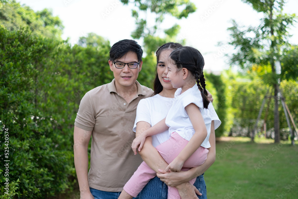 Portrait of an Asian family happy in the backyard. Asian young family enjoy happiness activity together in garden Portrait of an Asian family happy in the backyard. Asian young family enjoy happiness activity together in garden