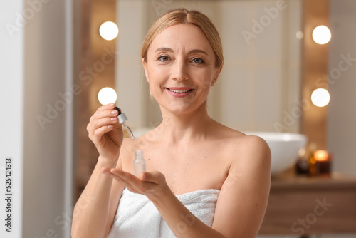 Mature woman using cosmetic...