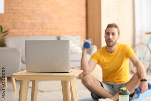 Sporty young man using lapt...