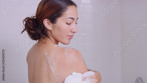 Brunette woman showers and relaxes while smelling aromatic body wash 