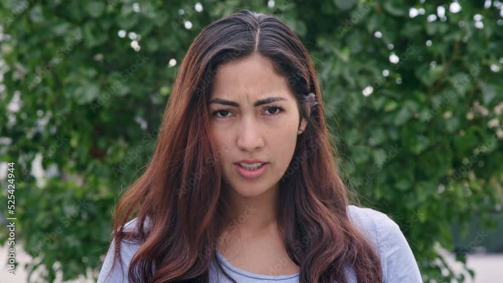 Angry brunette woman glares at camera with a huff and puff Angry brunette woman glares at camera with a huff and puff