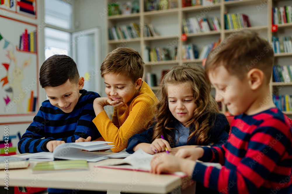 school children in the library reading books, doing homework, prepare a school project for lessons school children in the library reading books, doing homework, prepare a school project for lessons