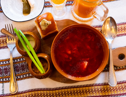 Borscht, beetroot hot soup and garlic bread pampushka on the table in a cafe photo