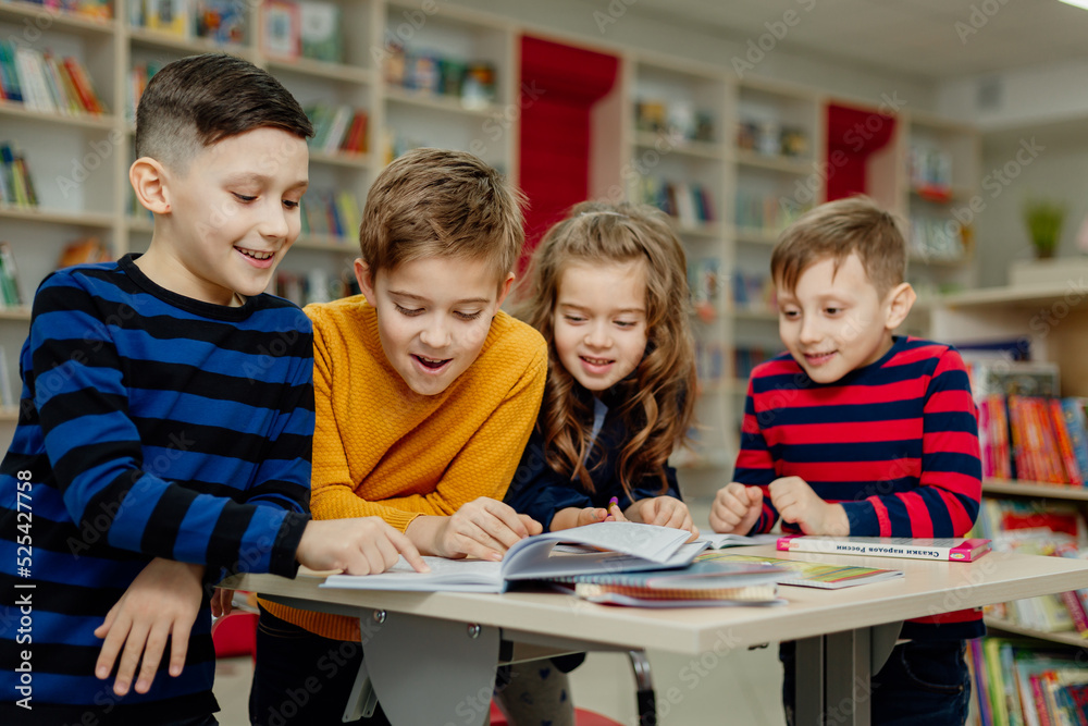 school children in the library reading books, doing homework, prepare a school project for lessons school children in the library reading books, doing homework, prepare a school project for lessons