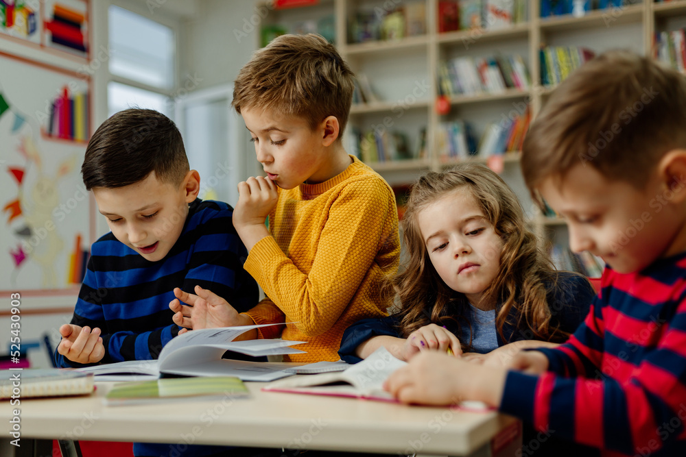 school children in the library reading books, doing homework, prepare a school project for lessons school children in the library reading books, doing homework, prepare a school project for lessons