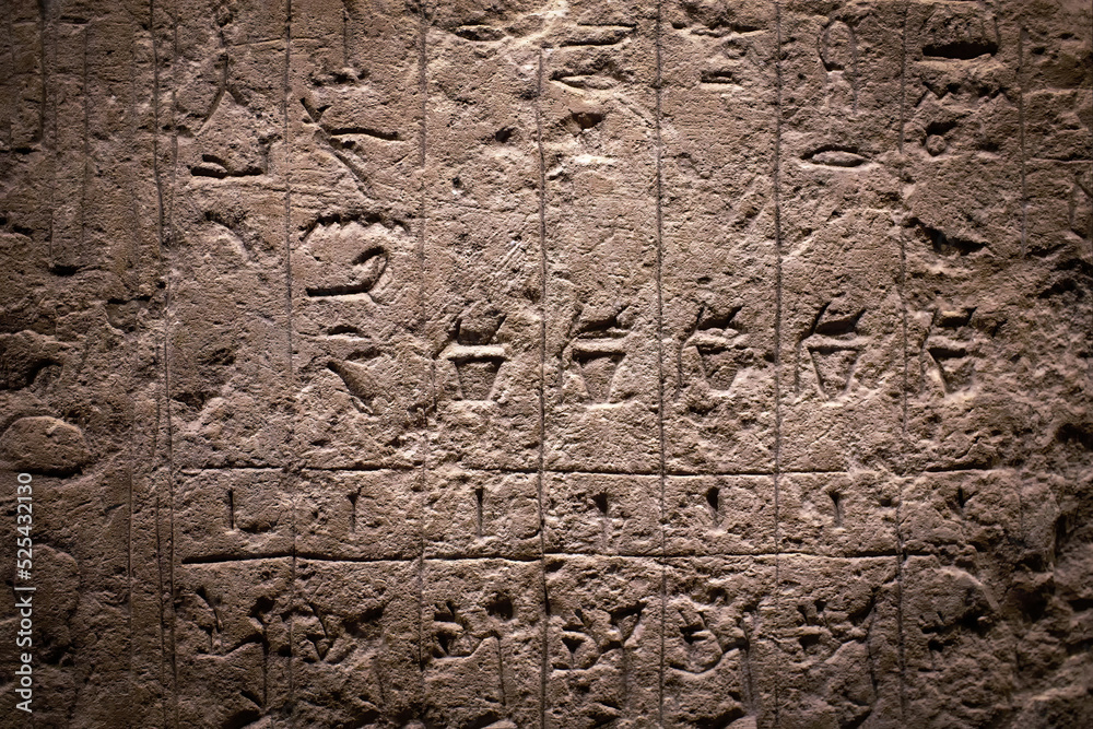 Egyptian hieroglyphs on a sandstone slab in the rays of the evening sun. Egyptian hieroglyphs on a sandstone slab in the rays of the evening sun.