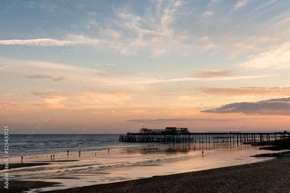 Beach during sunset with pier in the background