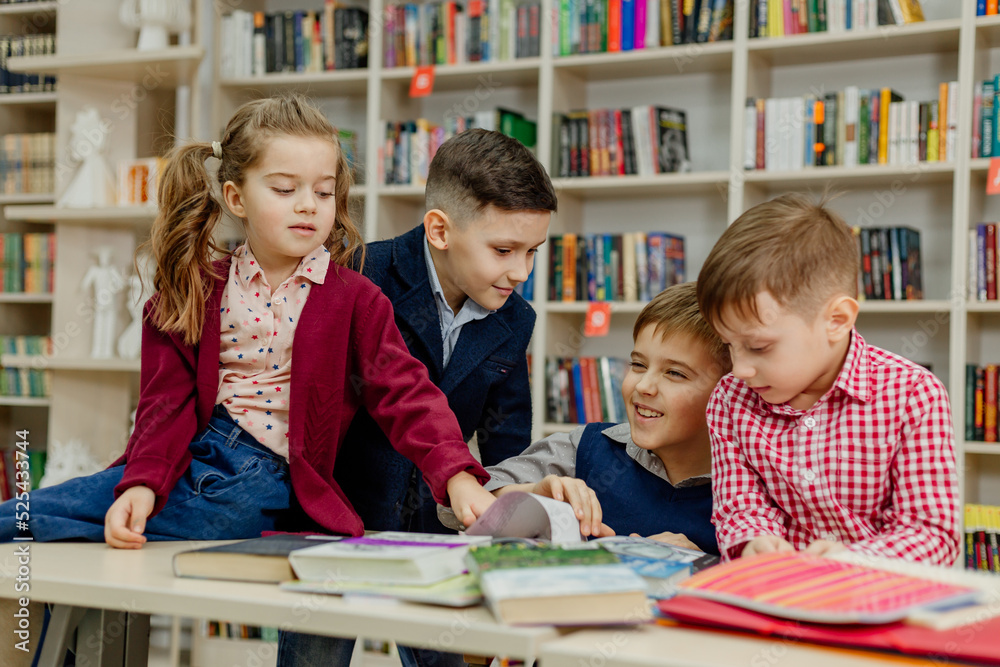 school children in the library reading books, doing homework, prepare a school project for lessons school children in the library reading books, doing homework, prepare a school project for lessons
