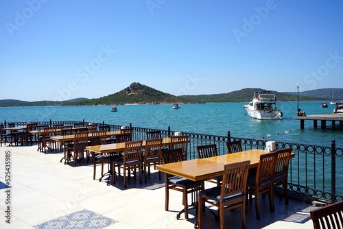 Terrasse eines Restaurant mit Tischen und Stühlen und Blick auf das Meer im Sommer bei Sonnenschein am Strand von Ayvalik in der Provinz Balikesir am Ägäischen Meer in der Türkei photo