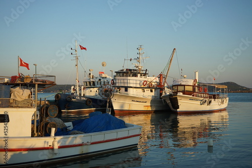 Alte Boote und Schiffe im Licht der Abendsonne im Hafen von Cunda bei Ayvalik am Ägäischen Meer in der Provinz der Balikesir in der Türkei photo