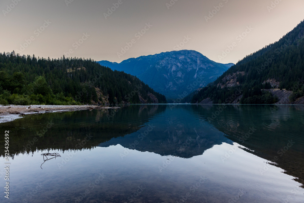 sunrise in still turquoise water of Thunder Arm in Diablo lake in Colonial Creek Campground in North Cascade National park, Washington