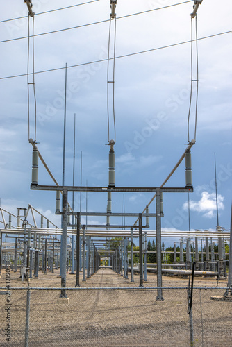 View inside of an electrical utility transformer station showing high voltage lines, pylons, insulators and bus bars, daytime, sunny, nobody