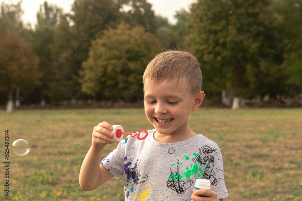 Little boy blowing soap bubbles in the park Little boy blowing soap bubbles in the park