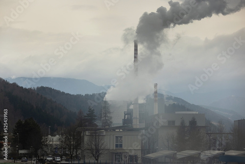 Top of the coal power plant chimney with white smoke, toxic emissions, rising in the sky, low angle shot. Air and environmental pollution concept.