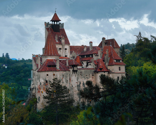View of Bran Castle on cliff top on background of thunderclouds, Romania