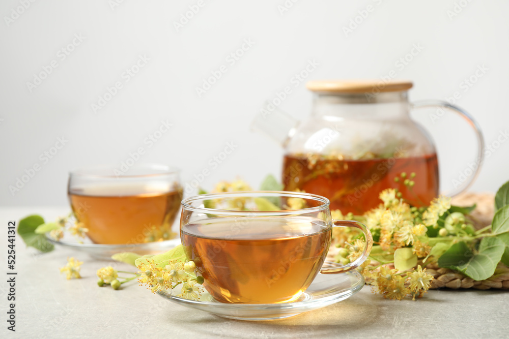 Tasty tea and linden blossom on light grey table. Space for text Tasty tea and linden blossom on light grey table. Space for text