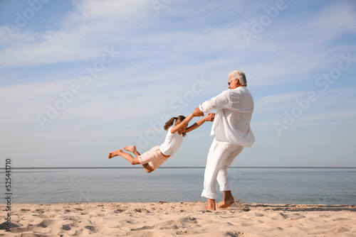 Photography Cute little girl with grandfather spending time together on sea beach