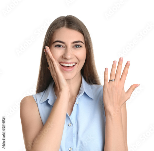 Happy young woman wearing beautiful engagement ring on white background