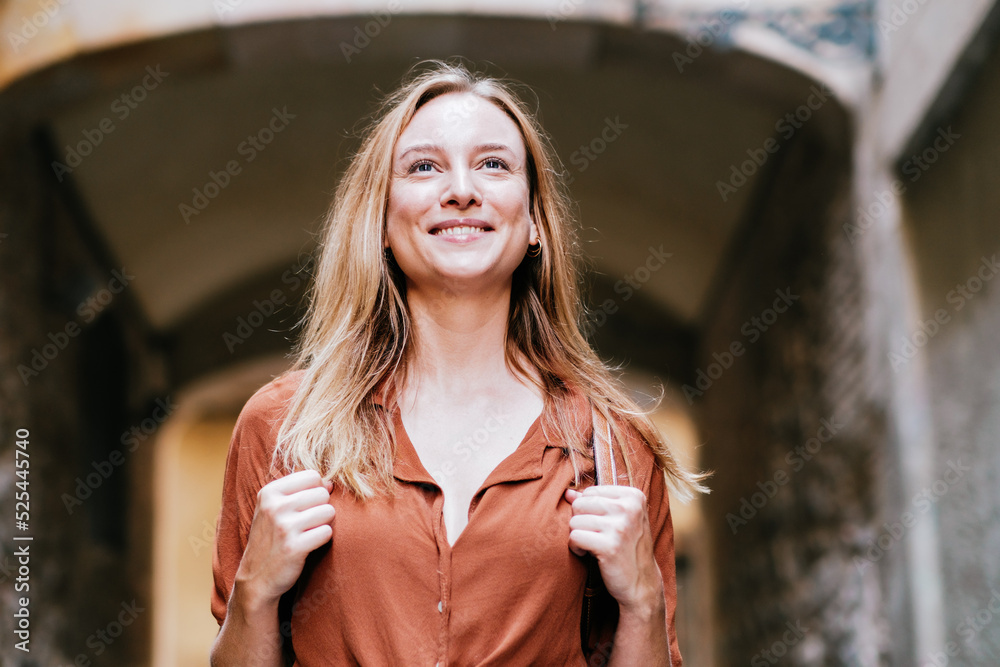 attractive blonde female tourist walking barcelona old town with her  backpack. She is smiling foto de Stock | Adobe Stock