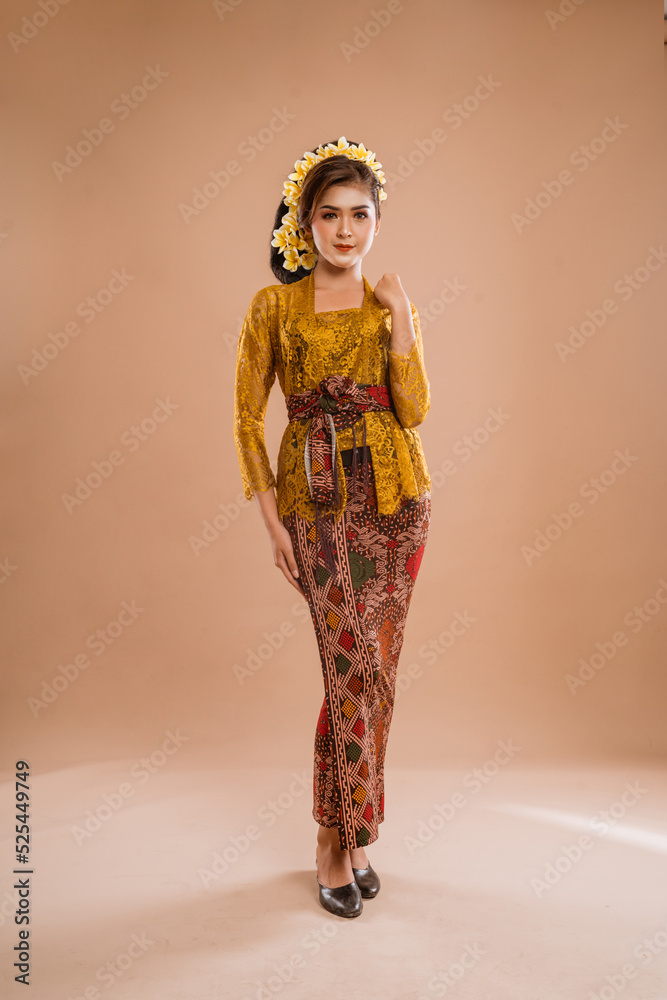 full body portrait of balinese woman wearing brown kebaya over isolated background