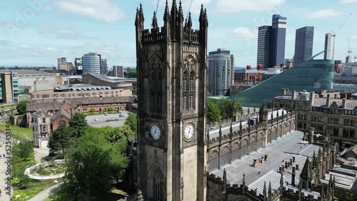 Aerial drone flight around Manchester Cathedral showing off the surrounding gardens and an array of skyscrapers and rooftops in the Background photo
