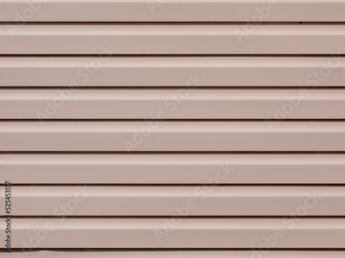 Plastic siding surface in pink tone. House wall, abstract background and texture