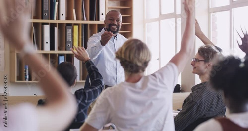 Teacher teaching students raising hands in a classroom at school answering questions. Clever, intelligent and smart teenagers getting a high quality education from a black male educator in class