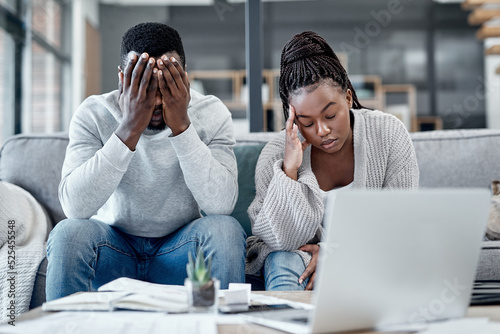 Stress, anxiety and worry with a young couple struggling with finance, debt and the home budget in the living room. Man and woman feeling negative and depressed with inflation and loan repayment photo