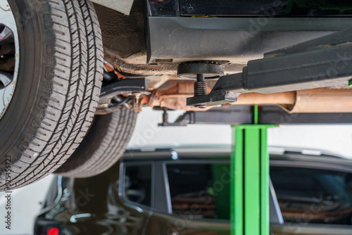 Carro suspenso em elevador hidráulico em oficina mecânica 