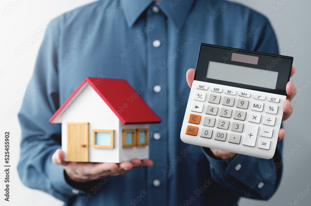 Man holding calculator and miniature house. The agent offering the price. Man holding calculator and miniature house. The agent offering the price.