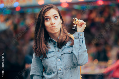 Funny Woman Winning a Small Trophy at Funfair Contest. Sore loser receiving a participation consolation prize
 photo